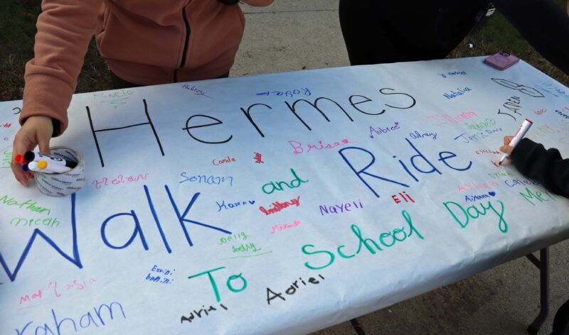 Students sign the walk to school day banner.